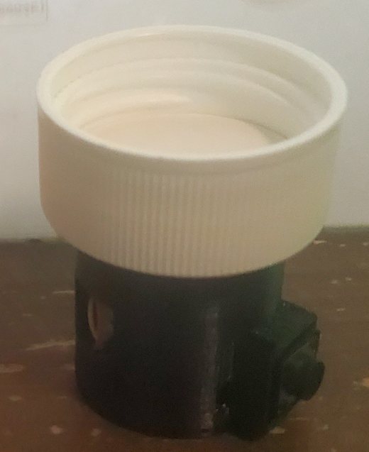 The cap with PillPuck attached, removed from the bottle